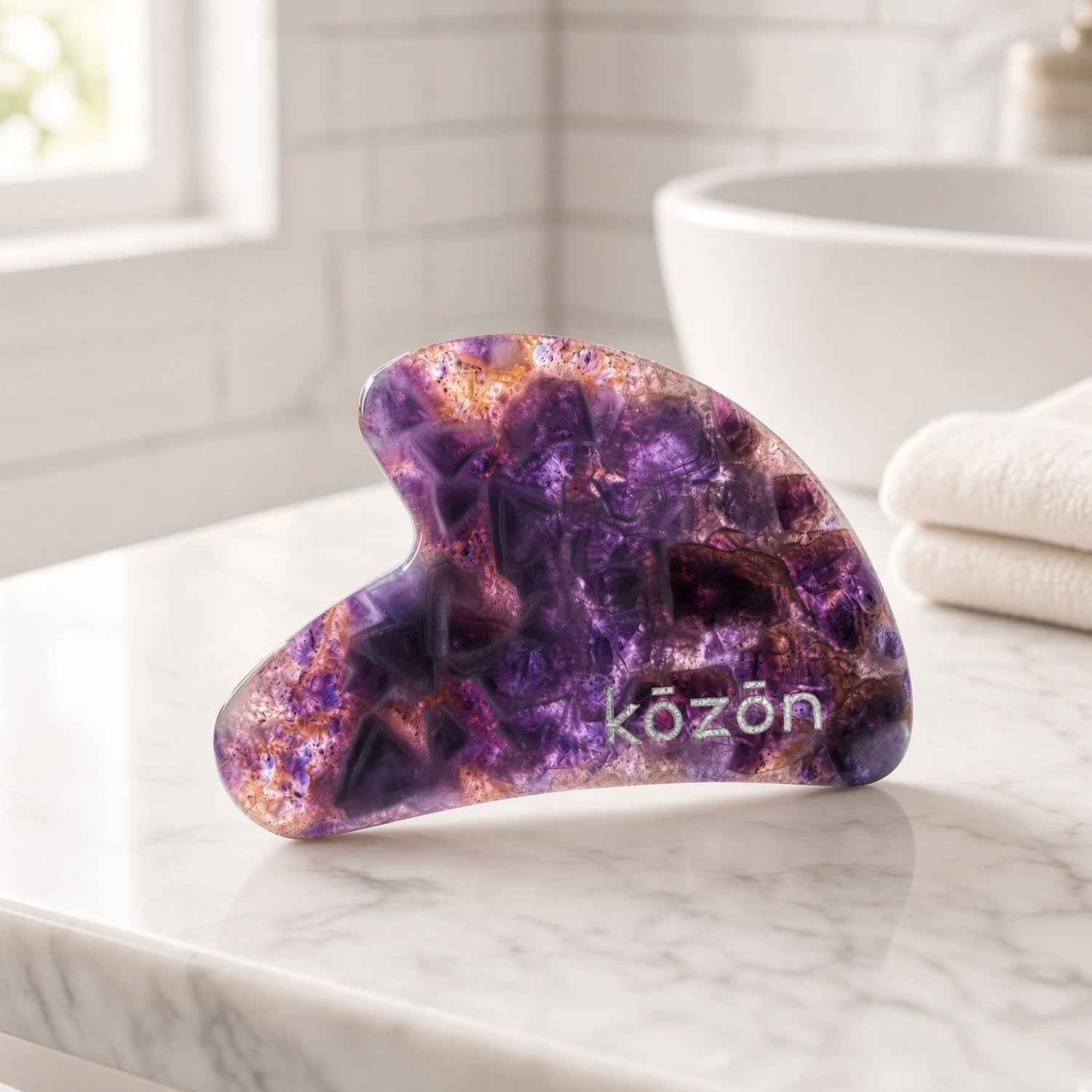 Kōzōn Amethyst Face Gua Sha stone on marble
