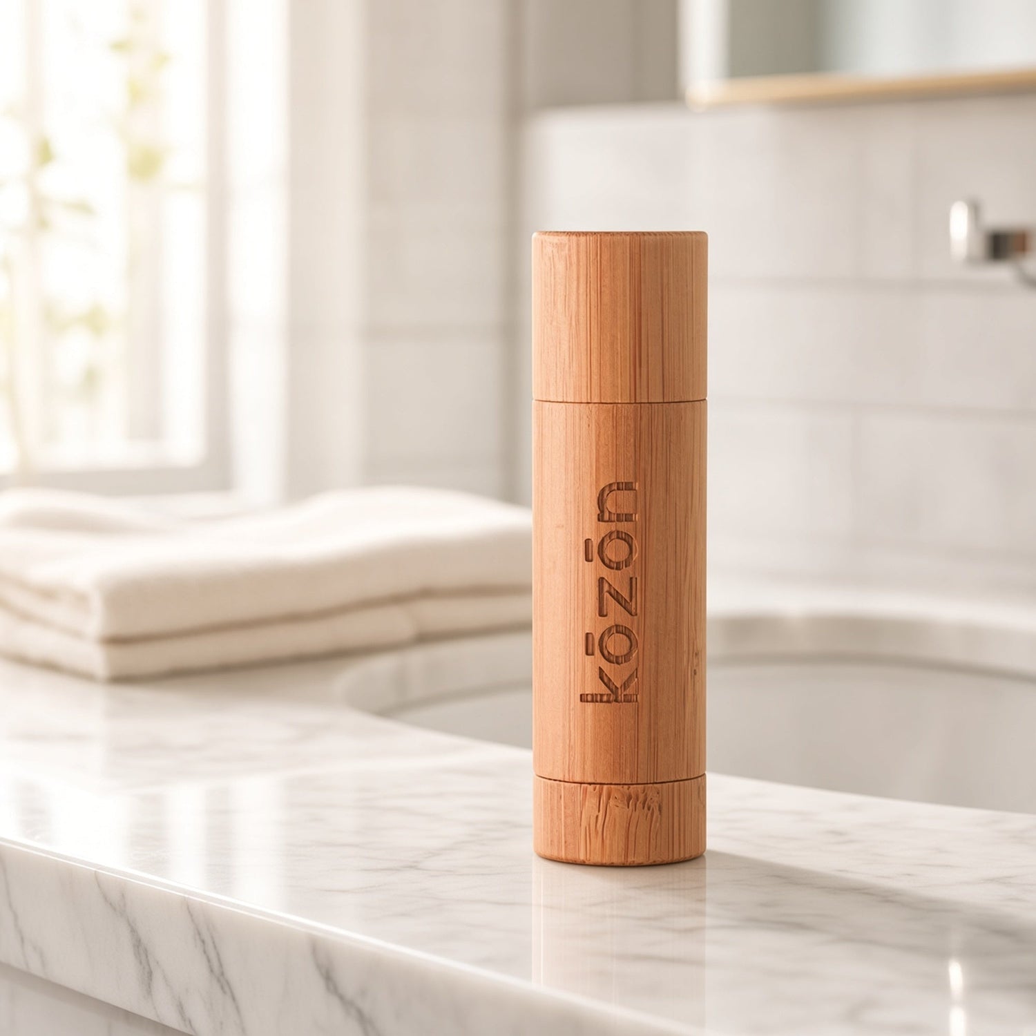 Kōzōn O3 Lip Balm in its bamboo tube on a marble counter